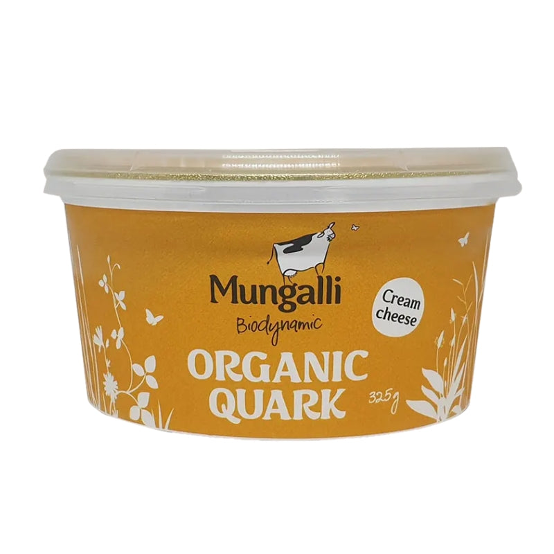 A 325g tub of Mungalli Organic Quark Cream cheese on a plain white background. The packaging features a warm mustard-yellow label with white text and illustrations of flowers and butterflies, and a black-and-white cow graphic.