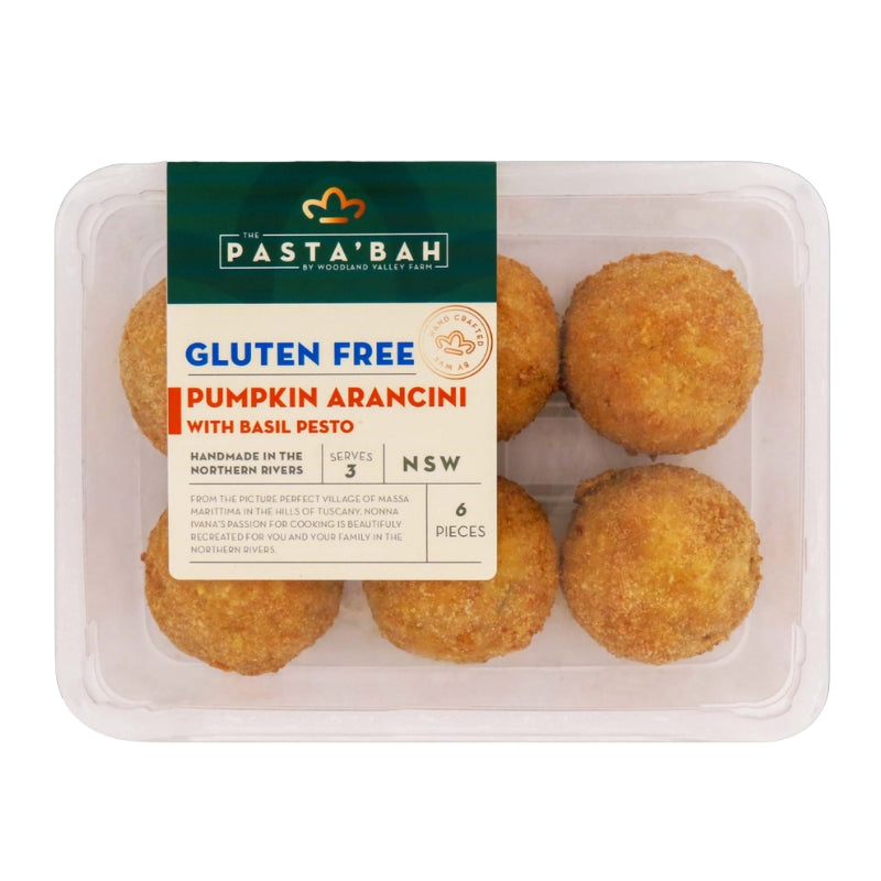 A clear plastic container holding six golden-brown fried pumpkin arancini balls, with a dark green and cream label reading 'Pasta'Bah Gluten Free Pumpkin Arancini with Basil Pesto'.