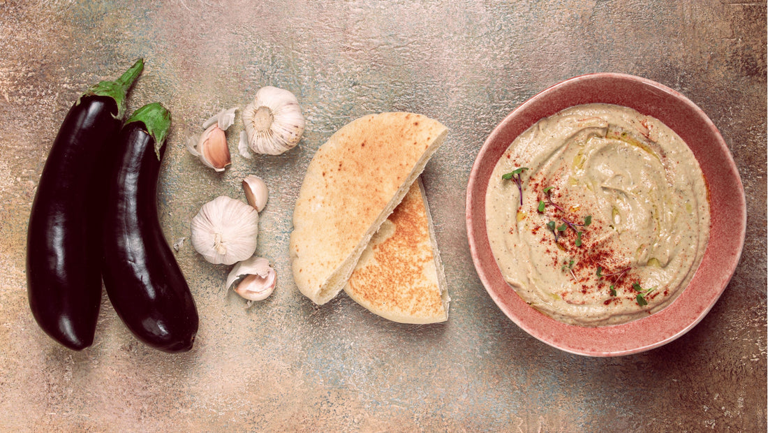Eggplant, garlic, pitta bread and hummus on a tabletop