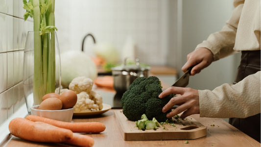 Fresh Broccoli on chopping board on a brown kitchen bench