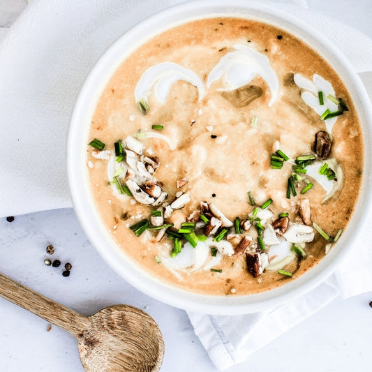 bowl of creamy soup with vegetables on a white background