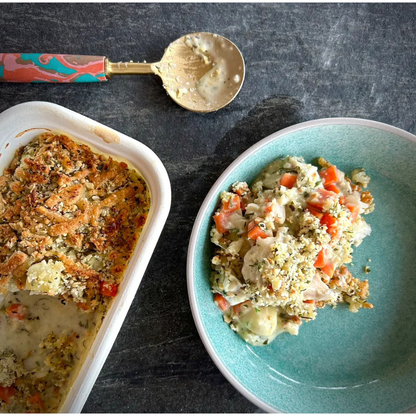 Two dishes of food, one in a white container and the other in a blue bowl, on a dark surface.