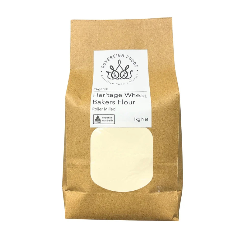 A 1kg bag of Sovereign Foods Heritage Wheat Bakers Flour, shown in its brown kraft paper packaging with a white label and a clear window displaying the flour inside.