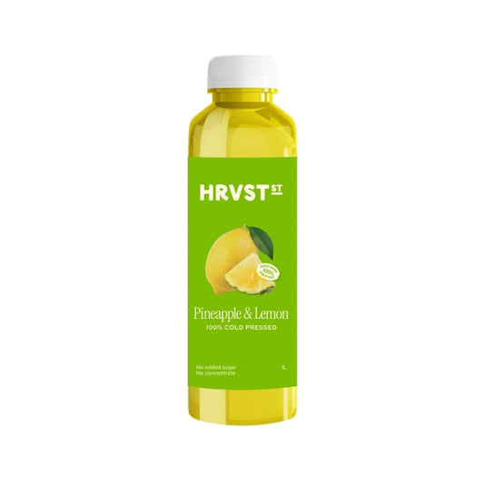 A bottle of HRVST II Pineapple & Lemon cold-pressed juice, featuring a bright green label with a yellow pineapple and lemon graphic, filled with yellow liquid and topped with a white cap, on a white background.
