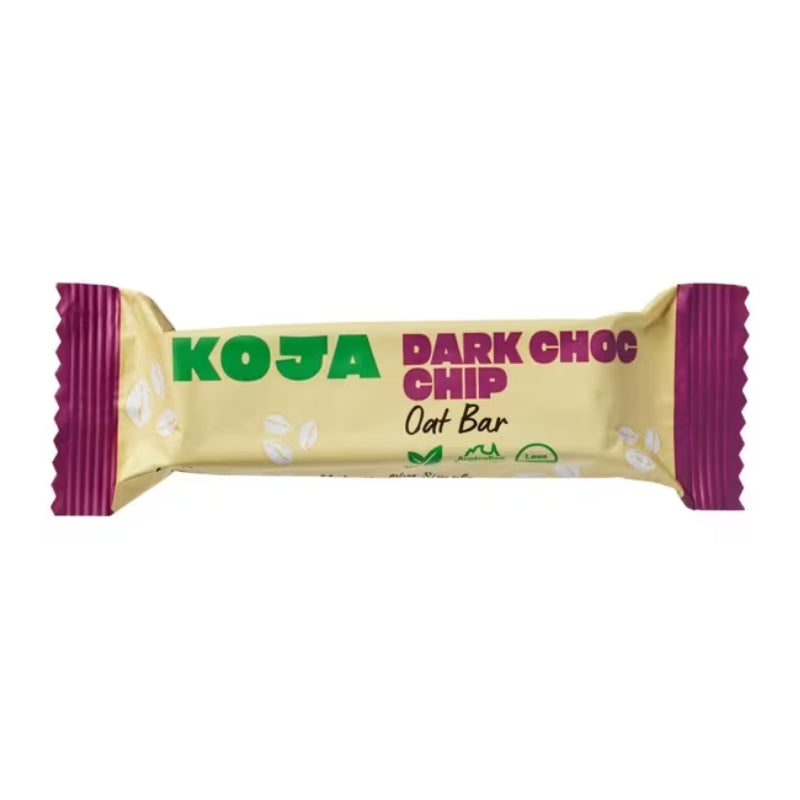 A single KOJA Dark Choc Chip Oat Bar in its wrapper, featuring a pale yellow-beige background with green and magenta text and purple crimped ends, shown on a plain white background.