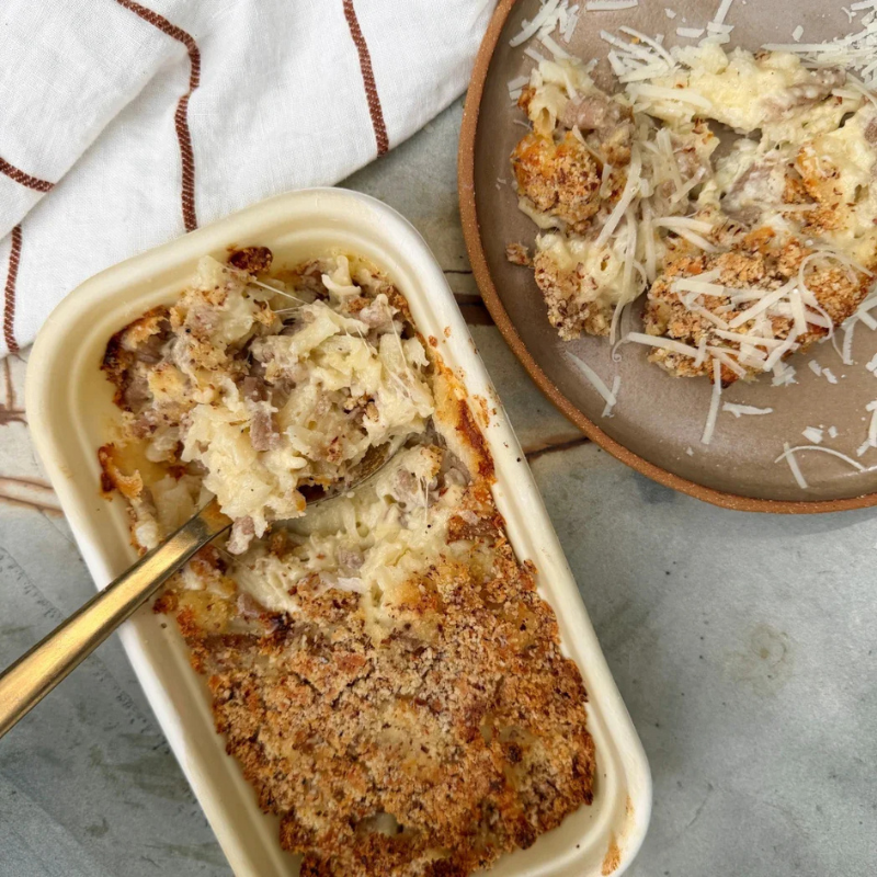 Baked Mac 'n' Cheese (Serves 2) with a scoop taken out, served on a plate with a fork.