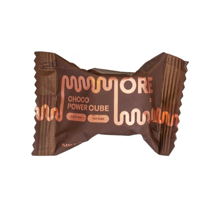 A single wrapped protein powder cube in a brown wrapper with copper-colored text reading 'MORE CHOCO POWER CUBE' on a plain white background.