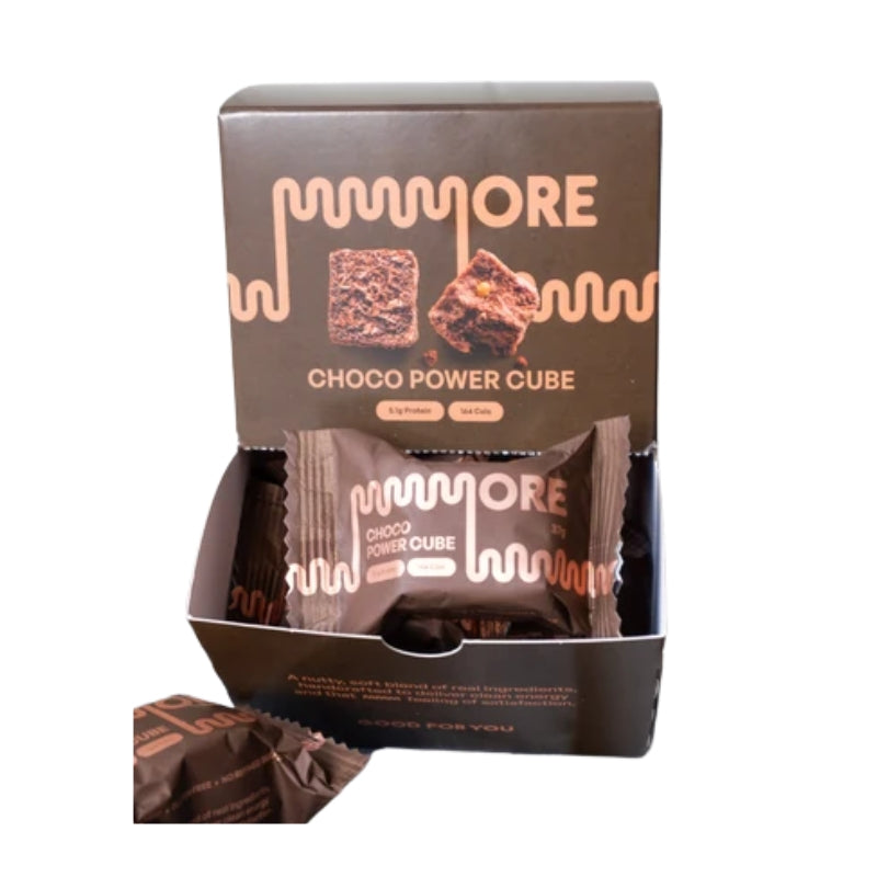 A box of MORE Choco Power Cube protein powder on a white background, with several individual packets displayed inside and in front.